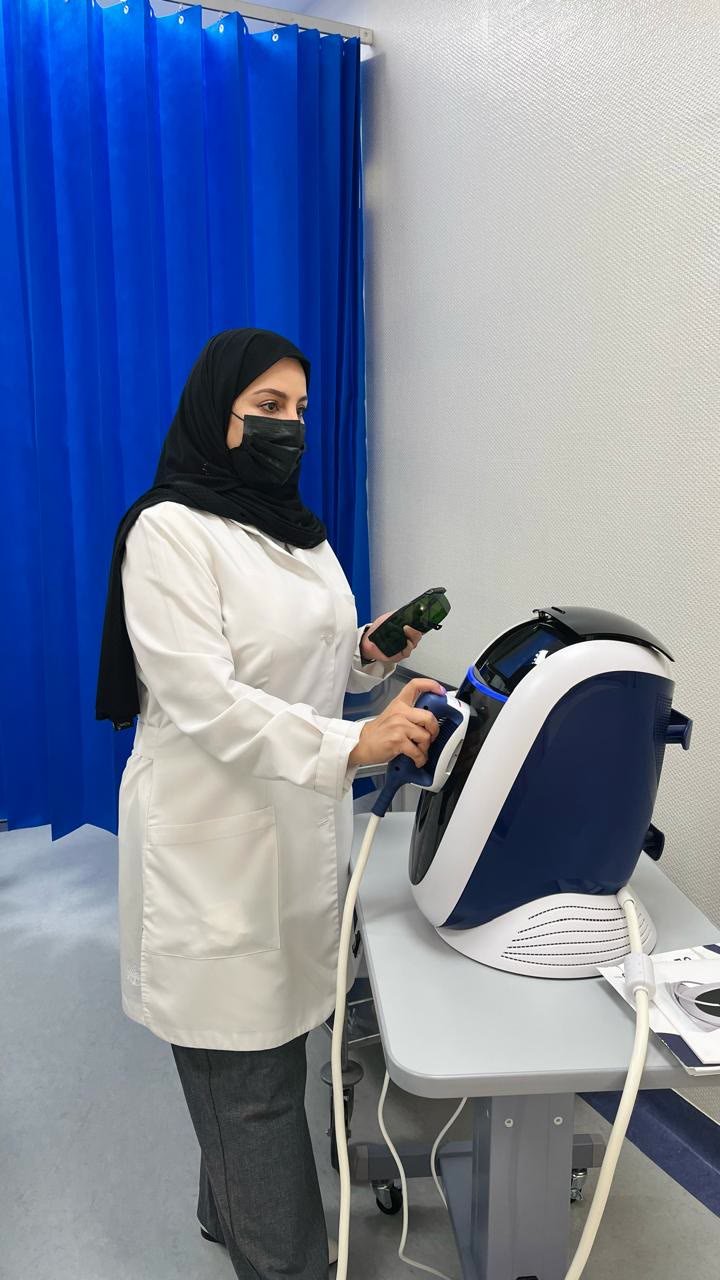 د. ولاء الديري أثناء تجهيز جهاز علاجي داخل العيادة